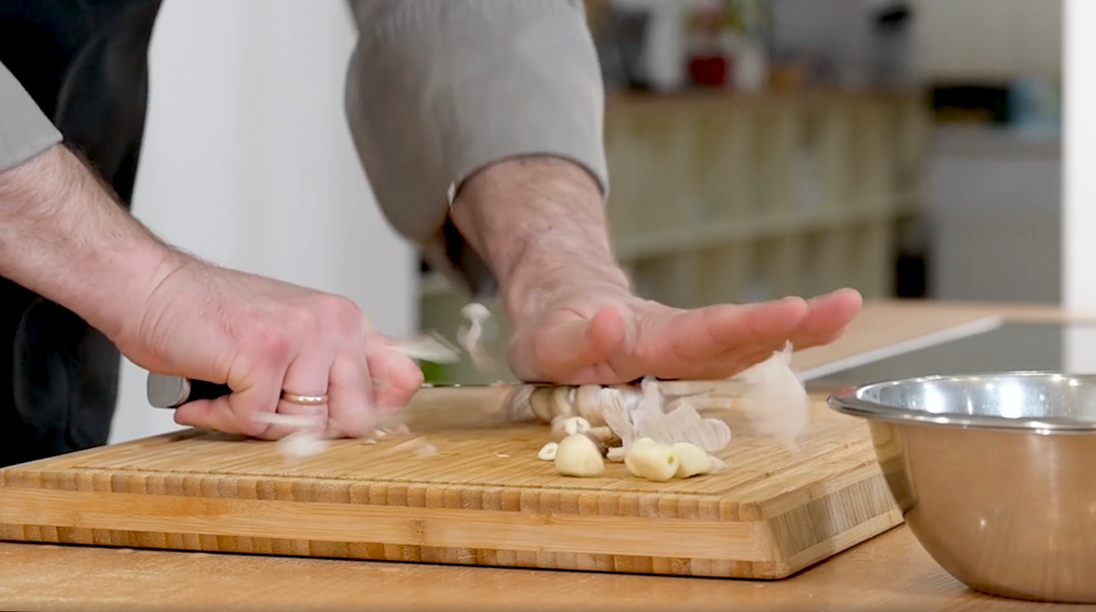 Ударом руки по ножу расплющиваем головку чеснока