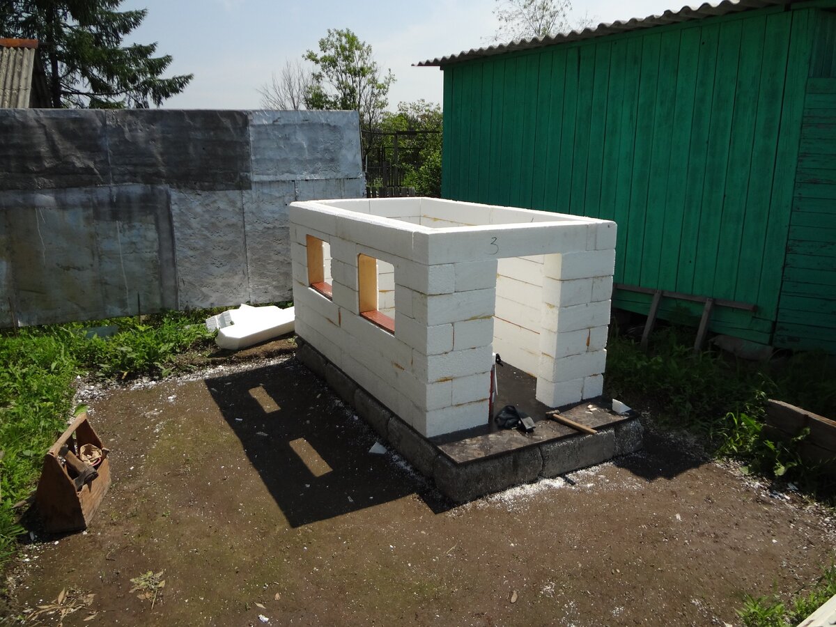 Фото автора. Домик из пенополистирола. Под фанерой, на грунте хорошо видны блоки из пенополистиролбетона (ПСББ), оставшиеся после строительства нашего дачного дома, которым не страшен ни мороз, ни дождь, ни переизбыток влаги, и этим блокам уже 30 лет. О них я расскажу в следующий раз.