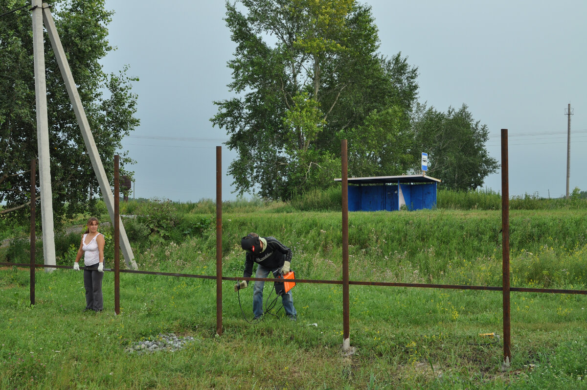 Делаем вдвоем с мужем забор с лицевой стороны участка. Он варит, я держу