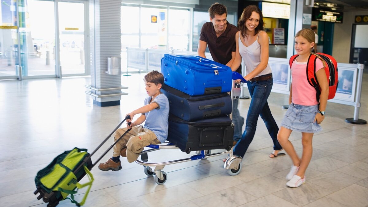 Семья из 4 человек с 5 сумками, возвращающаяся из отдыха.
