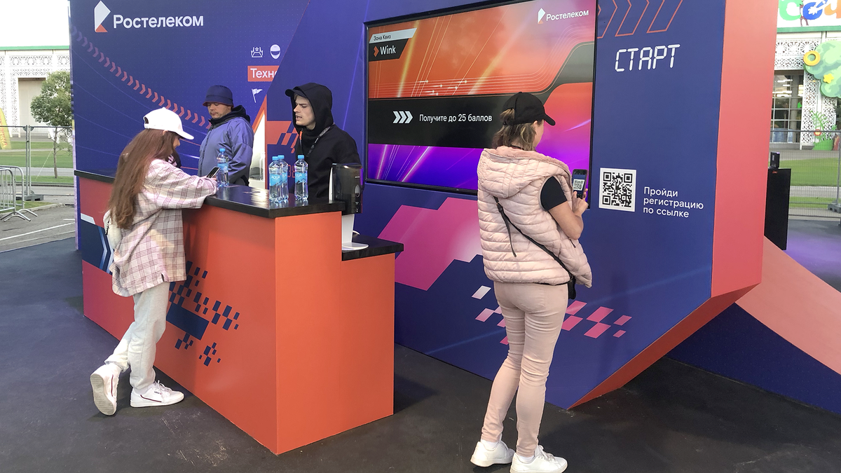 Посетитель стенда сканирует код для регистрации