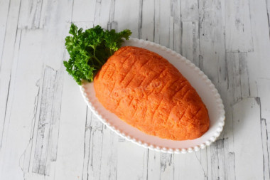 ПОШАГОВОЕ ПРИГОТОВЛЕНИЕ
Время приготовления: 2 ч
ШАГ 1:
Как сделать салат Морковка с копченой курицей? Подготовьте необходимые ингредиенты по списку. Копченую курицу можете заменить на обычное отварное или обжаренное филе. Майонез можете брать магазинный или приготовить самостоятельно.
ШАГ 2:
Картофель отварите в кожуре до готовности, охладите и очистите. Затем натрите на крупной терке.
ШАГ 3:
Морковь отварите, охладите, очистите и натрите на средней или мелкой терке. Если морковь водянистая, отожмите ее руками. Как варить морковь? Помойте ее и сложите в кастрюлю с холодной водой. Варите морковь после закипания на небольшом огне 20-25 минут, в зависимости от размера. Готовность проверьте острым ножом — он должен легко проткнуть морковку.
ШАГ 4:
Яйца сварите вкрутую, охладите и очистите. Затем натрите на крупной терке. Как сварить яйца вкрутую? Положите их в холодную воду, поставьте варить на небольшой огонь. Варите яйца 9 минут после закипания, затем залейте холодной водой и остудите. От резкого перепада температур скорлупа лучше очистится. По желанию можете белки и желтки натереть по-отдельности и сформировать из них два раздельных слоя.
ШАГ 5:
Копченую грудку очистите от кожи и костей и нарежьте небольшими кубиками. Грудку можете заменить на мясо с копченых окорочков.
ШАГ 6:
Маринованный огурец отряхните от рассола и нарежьте мелкими кубиками. Если огурец слишком водянистый, отожмите его от лишней влаги.

ШАГ 7:
На блюдо выложите слой тертого картофеля и придайте ему форму моркови. Сверху посыпьте картошку молотым перцем и полейте майонезом из кондитерского мешка.
ШАГ 8:
Далее распределите маринованные огурцы и также полейте сверху майонезом.
ШАГ 9:
На огурцы выложите ровным слоем копченую курицу. Можете также посыпать ее молотым перцем. Сверху сделайте сеточку из майонеза.
ШАГ 10:
Далее распределите тертые яйца.
ШАГ 11:
Всю поверхность салата покройте тертой морковью и пригладьте. Чтобы придать салату большее сходство со свежим овощем, силиконовой лопаткой сделайте в морковном слое неглубокие бороздки. Веточки петрушки вымойте, отряхните от влаги и воткните в место, где должна быть морковная ботва. Перед подачей поставьте салат на 1 час в холодильник. Приятного аппетита!