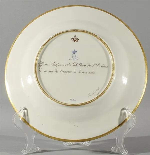 Однако факт есть факт. Оборотная сторона тарелки. Надпись по-французски  "Officiers Jupperieur et Jubalterne du de reserve des Casaques du 7 Escadron de la mer noire" переводится как: "Офицеры Жюпперьер и Жюбальтерн  из 7-го эскадрона резерва Черноморских казаков".  Вензель "Н I" синий подглазурный. Герб в виде двуглавого орла. Художник В. Столетов, 1834. Возможно, сия надпись означает, что офицерами в казачьих частях ставили наёмников-европейцев. (в данном случае - французов)? Фото взято из свободного доступа в интернете.