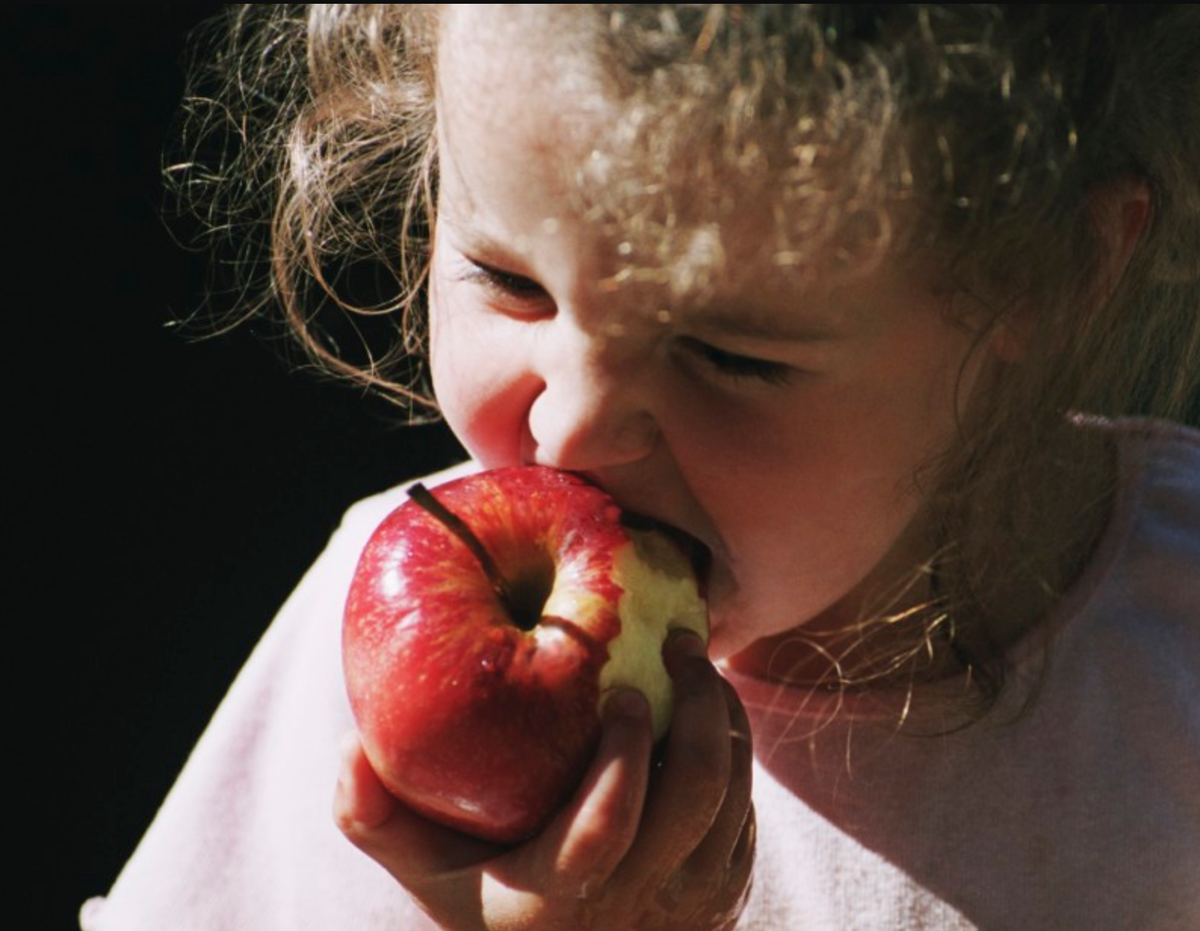 Укус яблока. Кусает яблоко. Откушенное яблоко. Грызет яблоко. Девочка откусывает яблоко.