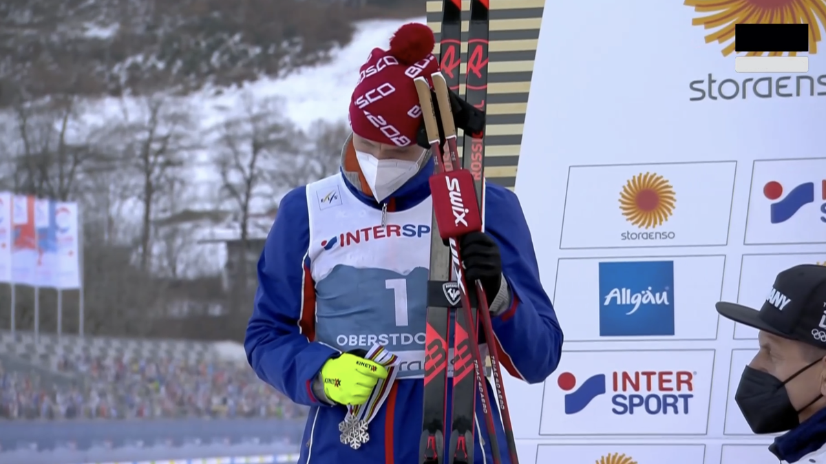 Александр Большунов не надевает серебряную медаль на награждении после марафона на чемпионате мира 2021.