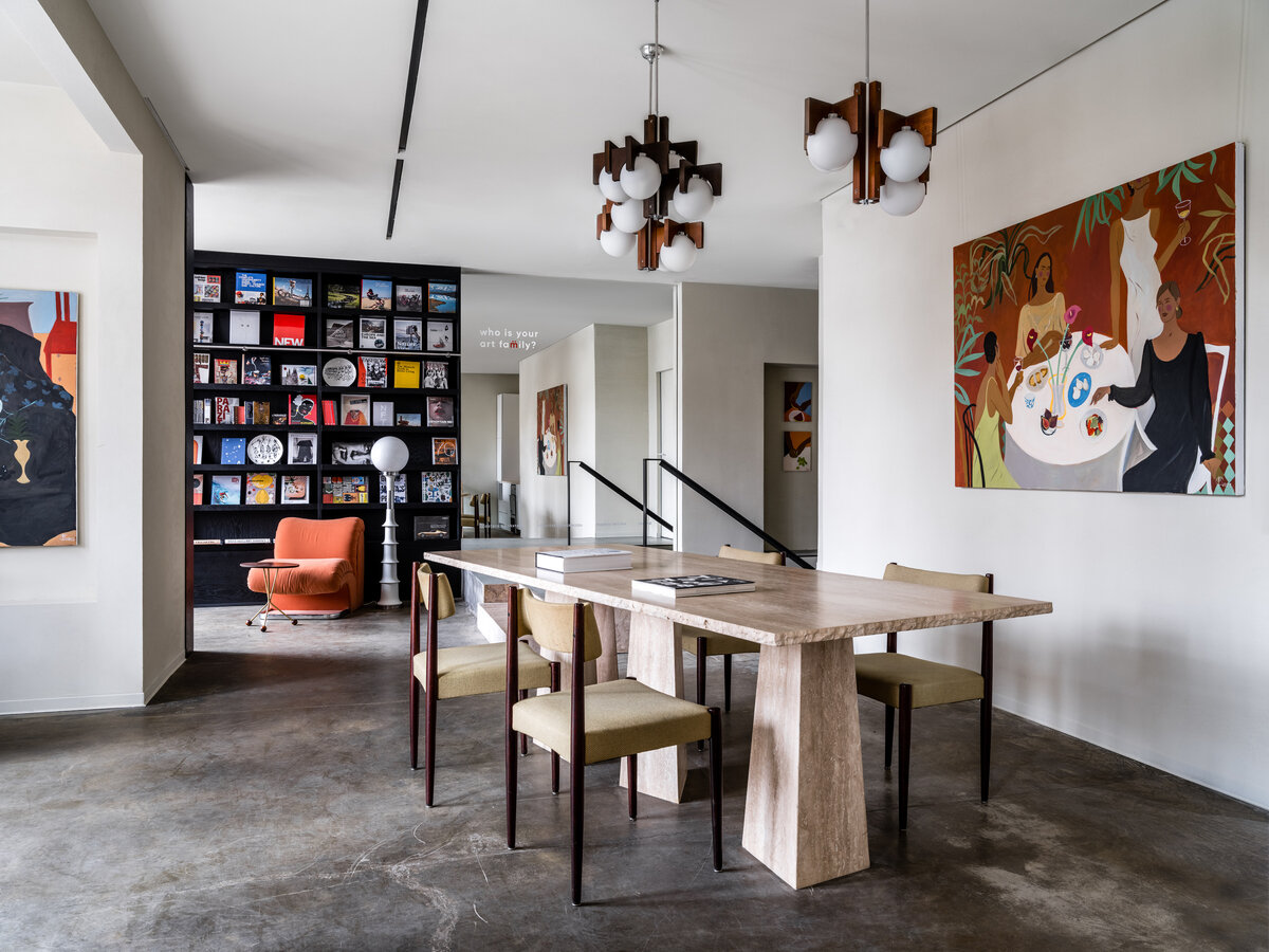 Стол из травертина сделан на заказ. Люстры, кресло и торшер винтажные. Живопись Елены Поповой.