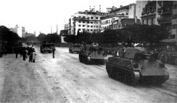АРГЕНТИНАПервые танки появились в Латинской Америке вскоре после Первой мировой войны. В 1921 году, закупив во Франции 12 легких машин FT17, ими обзавелась Бразилия. Вслед за ней последовали и другие государства континента. Более того, политически нестабильный регион стал ареной едва ли не первого боевого применения танков после Первой мировой войны. Речь идет о вспыхнувшей в 1932 году войне между Боливией и Парагваем известной под названием "Война Гран Чако". В этой войне Боливия использовала закупленную в Великобритании бронетехнику – три легких танка Vickers 6 ton и пять танкеток Vickers-Carden-Loyd Mk Vlb.На вооружении аргентинской армии танки появились во второй половине 1930-х годов. В 1937 году в Великобритании было закуплено несколько легких танков Vickers-Carden-Loyd mod. 1934, которые годом позже уже дефилировали по улицам Буэнос-Айреса. Эти машины использовались, главным образом, в учебных целях. Полноценными же боевыми танками должны были стать чехословацкие LT vz.38, переговоры о поставке которых велись весьма интенсивно. Планировалось закупить 160 боевых машин этого типа, но Мюнхенский пакт и последовавшая вслед за ним оккупация Чехии расстроили сделку. Начавшаяся Вторая мировая война вообще похоронила планы аргентинских военных по закупке вооружения за границей. Дело в том, что правящие круги этой страны симпатизировали гитлеровской Германии и страны, воевавшие с нацистами, е первую очередь США, ввели эмбарго на поставки в Аргентину оружия и боевой техники. Пришлось развивать собственное танкостроение. Впрочем, успехи на этом поприще у аргентинцев были более чем скромными.В 1942 году подполковник Альфредо Баиси спроектировал средний танк D.L.43, получивший название Nahuel ("Ягуар" – в переводе с языка индейцев аракуана). Работы над аргентинским танком шли быстро – деревянный макет в натуральную величину изготовили, например, за 45 дней. В основу машины положили конструктивные решения, использованные на американских средних танках. Серийное производство началось в 1943 году, но продолжалось недолго – возможности аргентинской промышленности были ограничены.С окончанием Второй мировой войны эмбарго с Аргентины было снято, начались поставки американской и английской боевой техники и необходимость в производстве собственного танка отпала.Средние ганки Nahuel D.L.43 во время военного парада в Буэнос-Айресе 9 июля 1944 г.