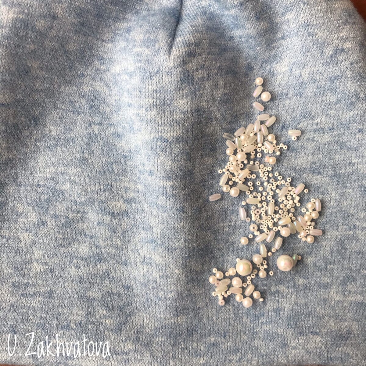 Высыпаем бусины и бисер на шапку и пальцев придаем узор.