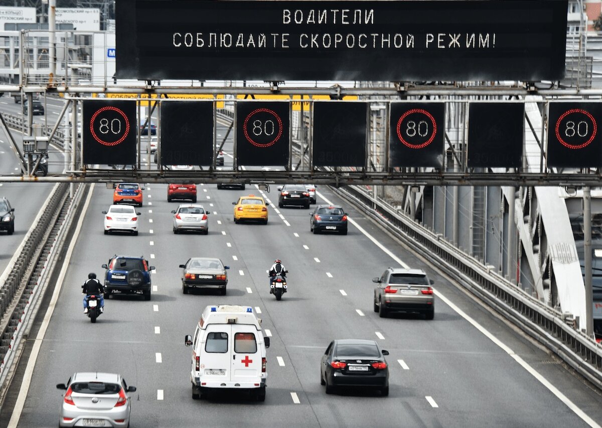 В целях снижения скорости на магистралях, к примеру, при плохих погодных условиях, появилась новая технология, включающая в себя дорожные знаки с переменной информацией и комплексы фиксации соблюдения данных знаков. Как же это будет работать? 	Как правило водителям можно только напомнить, что при плохих погодных условиях, лучше снизить скорость. Данную функцию выполняют стационарные знаки, но они носят рекомендательный характер, их соблюдение не обязательно и никак не наказывается. К примеру, при допустимой скорости в 90 км/ч. при дожде рекомендуется снизить скорость до 70 км/ч.. Многие не обращают на это внимание, но по оценкам ситуации на дорогах, не соблюдение данных рекомендаций может привести к ДТП. Необычное и довольно простое решение было найдено компанией «Технологии распознавания», они предложили электронные знаки переменной информации «ограничения максимальной скорости» и автоматическую систему контроля для соблюдения требований при помощи камер.
	В зависимости от погодных условий, данные знаки позволят менять информацию о допустимом скоростном режиме, которая будет отображаться на электронном табло. Над дорожным полотном будут установлены электронные знаки, при ухудшении погоды данные о скоростном режиме меняются, при этом требование знаков будут носить обязательный характер, их игнорирование приведет к штрафам. Для фиксации нарушения будет использоваться фото и видео фиксация, камеры будут контролировать подъезд автомобиля к знакам и на расстоянии примерно 50 метров будут установлены камеры, которые будут контролировать отъезд от знаков. На снимках будет видно не только автомобиль и его госномер, но и информация, указанная на знаках – это исключит спорные моменты при составлении постановления. Такая система, как утверждают специалисты, будет эффективнее и удобнее чем замер средней скорости. Такие знаки должны стать частью интеллектуальной транспортной системы. Подобные табло, со знаками переменной информации уже используются, но раньше камеры не фиксировали сам знак, приходилось синхронизировать работу знаков и камер.
Источник информации автоньюс
