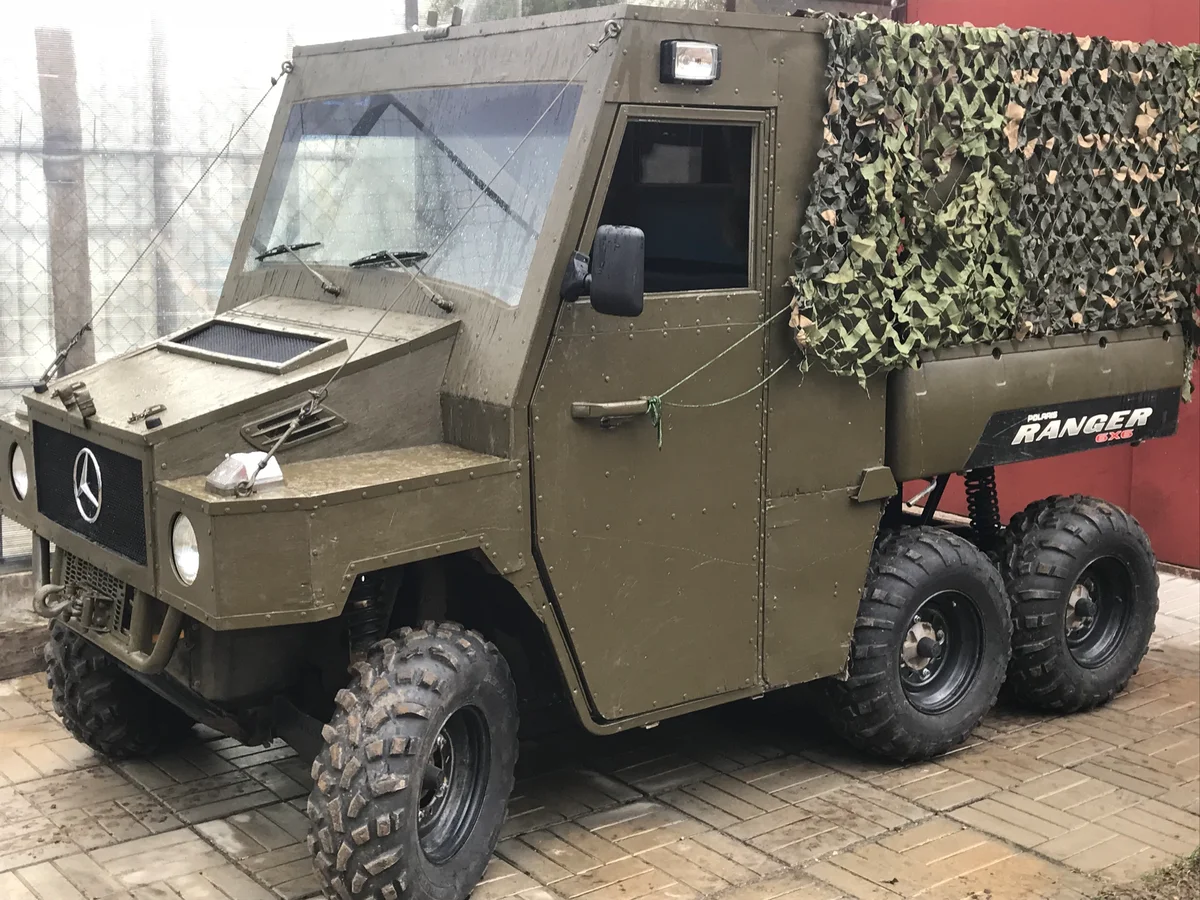 Самодельная кабина прекрасно стилизована под Гелик! Даже эмблему  повесили с характерными фарами. Источник фото - https://auto.ru/atv/used/sale/polaris/ranger_6x6/3366496-60a1bd8d/