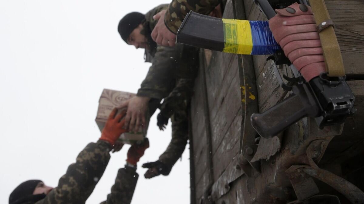    Украинские военнослужащие разгружают коробки с продовольственными пайками© AP Photo / Petr David Josek