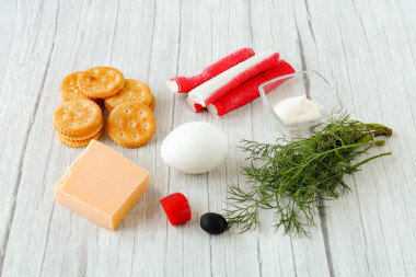 ШАГ 1:
Как сделать закуску на крекере с крабовыми палочками? Подготовьте необходимые ингредиенты. Печенье крекер лучше взять несладкое или солоноватое.