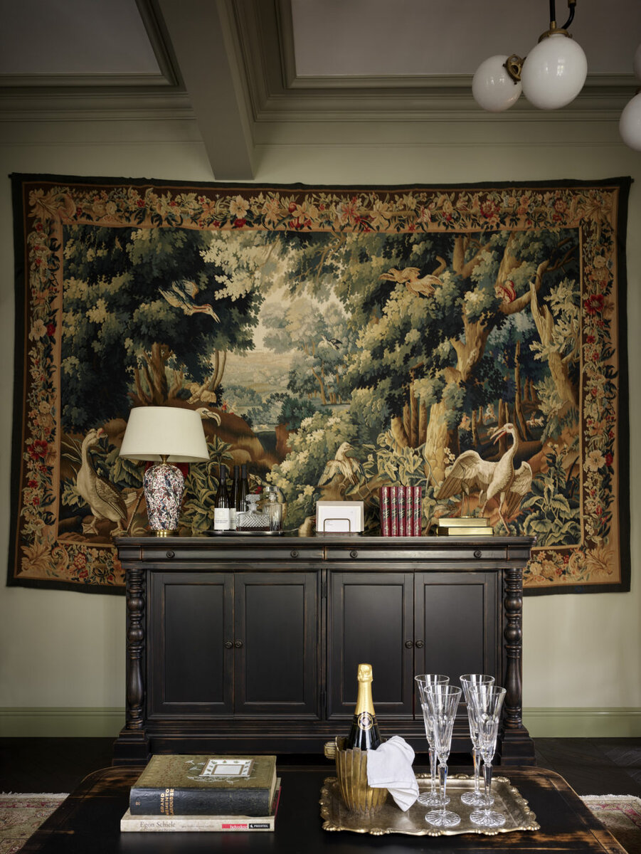 Гостиная. Журнальный столик сделан на заказ в мастерской “НВС”; винтажные ботанические иллюстрации из art NE gallery, в багетах от “Рама в интерьере”; ваза из салона “3 Сороки”; бокалы из мастерской Кати Гердт; ведро для шампанского, Redecoration Store; книги, cалон “Коллекция”; комод, Schnadig; на нем винтажная лампа из Redecoration Store;­ ковер и гобелен, MarkPatlisStudio.