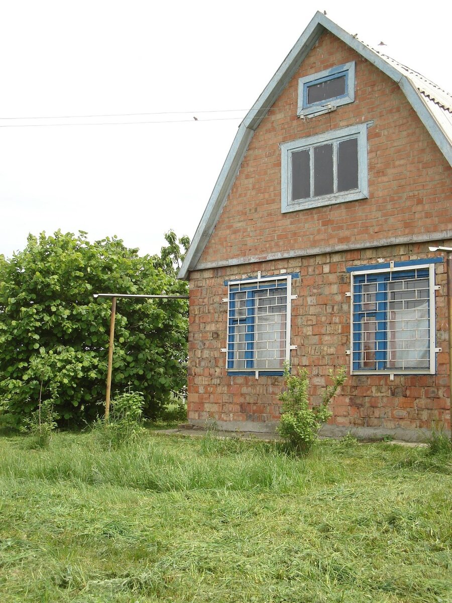 Так выглядел наш дом. Бывшие владельцы возле дома сажали картошку. Газон посадили уже мы