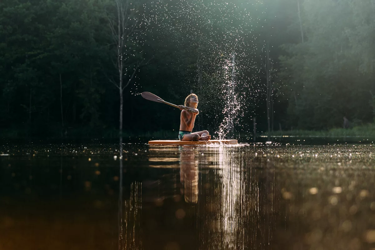 Следите за водой. Озеро брызги. Девушка плескается в воде.