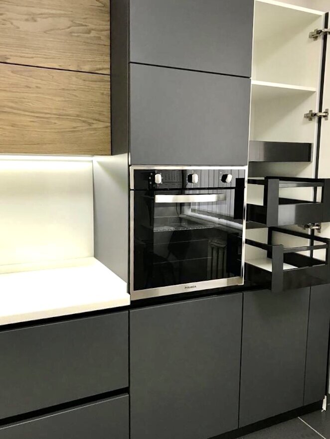 В группе пеналов, правая часть кухни, мы разместили встроенный духовой шкаф, а рядом интегрировали полезные выдвижные ниши и выдвижную корзину (высота 2.2 м), где есть также держатель для швабры