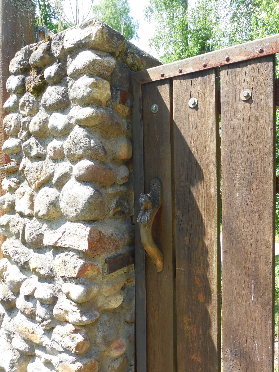 Обратите внимание на дверь (калитка). На двери необычная ручка. Кажется, это медведь?