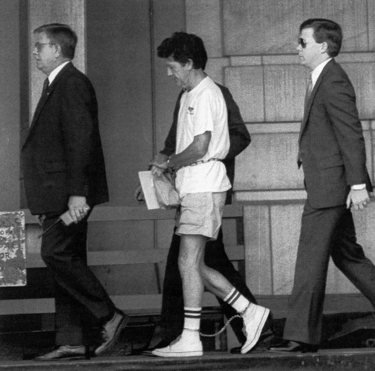 Уолтера Муди (в центре) ведут в здание федерального суда в Мейконе, штат Джорджия, во время слушаний в 1990 году