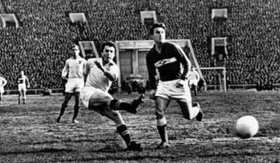 Геннадий Гусаров (в белой форме) наносит удар по воротам. Источник фото.