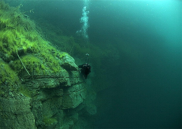 Голубая карстовая бездна в Кабардино-Балкарии. Снаружи в озеро не впадает ни одна река, оно питается подземными источниками. Голубой цвет озера обусловлен высоким содержанием сероводорода в воде. Жутковатость этому озеру придает тот факт, что никто не смог выяснить его глубину. Дело в том, что дно состоит из разветвленной системы пещер. Исследователи до сих пор не смогли выяснить, что представляет собой нижняя точка этого карстового озера. Считается, что под Голубым озером самая большая в мире система подводных пещер.