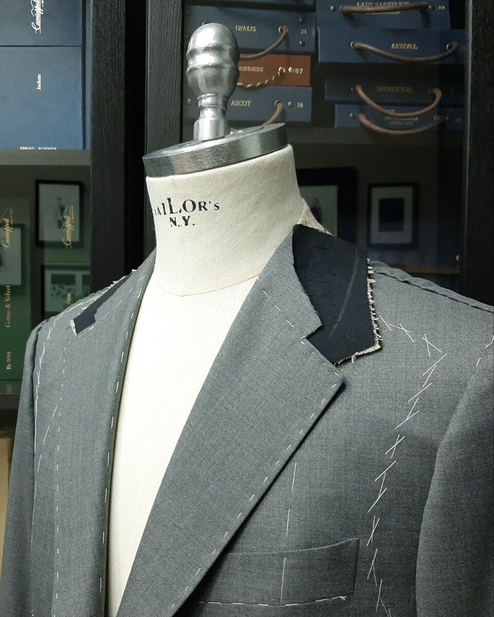 Несколько костюмных пиджаков в разных оттенках серого на стадиях промежуточных примерок