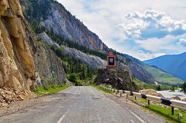 В Акташе поворачиваем на Улаган.Попасть на южную оконечность Телецкого озера можно тремя путями: 1) через поселок Артыбаш, а там из поселка Иогач по озеру на теплоходе; 2) через кордон в поселок Яйлю; или же 3) через перевал Кату-Ярык, вдоль бассейна реки Чулышман. Первые два пути уже нами освоены ранее. А вот третий был всегда в планах. И вот, разнообразия для и путешествия ради, туда и нацелились. 
Из Новосибирска выехали "с рассветом", дабы избежать плотного пригородного трафика (ведь суббота, лето). Перед Маймой встретились с Колей (NSM) и, уже вместе, по Чуйскому тракту. Уж полдень близился, и солнце в зените, а день, к тому же, обещал быть очень жарким. Понятно, что электронный термометр показывает +34. Это на своей шкуре прекрасно чувствуется и без него. Особенно на вынужденных остановках, когда по спине и из-под шлема начинает предательски капать. «Да здравствует ветер, который в лицо!».Остаются позади затяжной подъем на Семинский перевал и змеистый на Чике-Таман.Увлекшись, чуть не проскочили. Мы с Вадиком впервые на месте слияния Чуи и Катуни – чтимом и священном для алтайцев.Катунь голубая, Чуя - коричневая.
Видна дорога за рекой в отдаленные деревни.Панорамка места слияния.На 742 км трассы из-за очередного поворота ожидаемо возникла турбаза Ак-Боом, пока единственная на этом участке. По написанным от руки объявлениям на базе предлагаются домики, гостиница, баня, озеро, лошади, сплав, экскурсии, водопад, петроглифы и прочая куча всяких возможных благ, заманивающих туристов.Большие поляны, еще не застроенные домиками, предлагаются как места для палаток. Располагаемся под березками. Рядом шумит река.По подвесному мостику идти страшновато. Он шаткий, раскачивающийся и уже потерявший некоторые ступеньки. На другом берегу  тоже домики этой базы.Коля озадачился разборкой своего мотоцикла.А не лучше ли в такую жару озадачиваться купанием. Например, в маленьком озере-запруде, которое образовал горный ручей, рукотворно перегороженный каменьями.Вода в нем ледяная, сводит ноги, но, хоть ненадолго, приятно освежает.В этом месте Чуйского тракта стоит памятник водителям, погибшим на трассе.А так же незамысловатая поэма о Кольке Снегиреве,  написанная на постаменте с грузовиком-полуторкой.