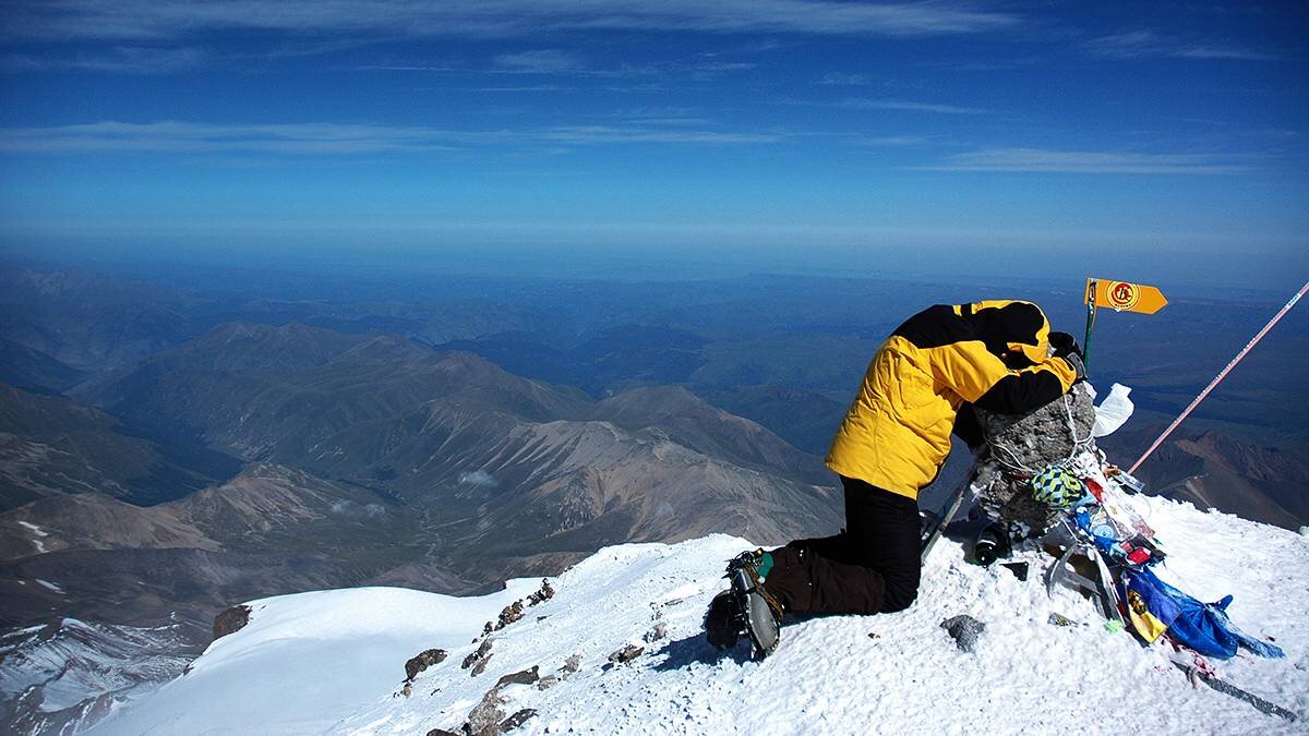 Уставший альпинист на вершине Эльбруса