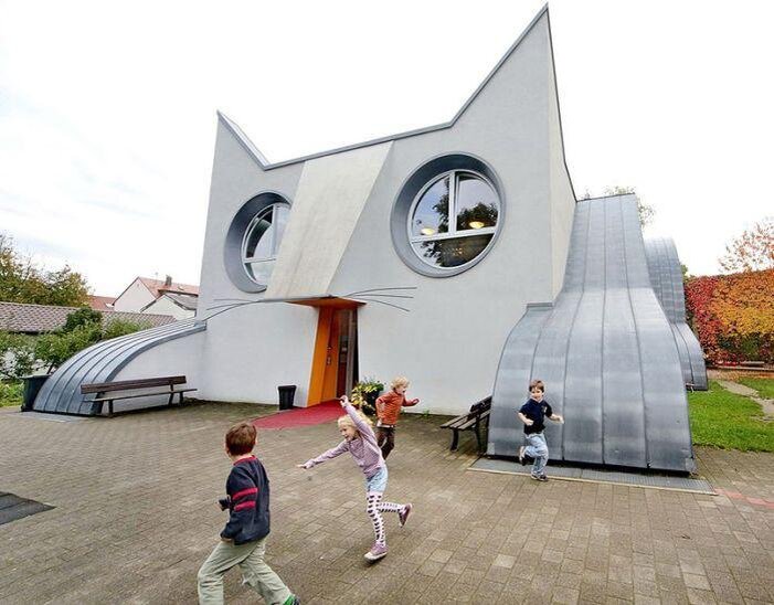 Здание необычного детского сада «Kindergarten Die Katze» в городке Wolfartsweier появилось благодаря работе дизайнера Томи Унгерер и архитектора Айла-Сюзан Йондель. Двери в детский сад - это «рот». Внутри «лап» - игровые площадки, а в «животе» размещены раздевалка, игровая комната, рассчитанная на 100 человек, кухня, столовая и лестница.