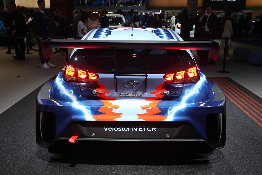 Компания Хендай привезла во Франкфурт свой первый гоночный электрокар — модель Veloster N ETCR. Модель была построена усилиями специалистов подразделения Hyundai Motorsport, что в немецком Альценау. Сообщается, что работы над данным автомобилем начались в ноябре две тысячи восемнадцатого года, при этом первый рабочий прототип был готов лишь в августе девятнадцатого. Модельный ряд Hyundai Снаружи гоночный Велостер на электротяге обращает на себя внимание броской окраской кузова с молниями на боковинах. Интересно, что колеса такого хэтчбека разноцветные. Спереди здесь установлены ярко-оранжевые диски, а сзади — темно-синие. Трековый Veloster N ETCR построен на базе дорожного Veloster N. От донора новинка отличается полностью электрической технической начинкой. Она включает четыре электромотора, при этом привод здесь — задний. Отдача движков не уточняется, но известно, что машина массой 1 700 кг имеет батареи емкостью 65 кВтч. Поскольку данная модель позиционируется прямым конкурентом гоночному электрокару Cupra e-Racer, то можно предположить, что суммарная производительность ее электромоторов находится в районе 700 л.с., а значит планку с 0-100 км/ч пятидверка должна разменивать примерно за 3,0 секунды. Сразу после выставки корейцы приступят к тестированию машины, после чего компания построит несколько экземпляров, которые примут участие в новой гоночной серии ETCR, первые заезды которой состоятся в 2020 г. Заметим, что в компании планируют использовать полученный при разработке гоночного Veloster N ETCR опыт и для создания серийных электрокаров. Источник: https://www.allcarz.ru/veloster-n-etcr/ @ allcarz.ru