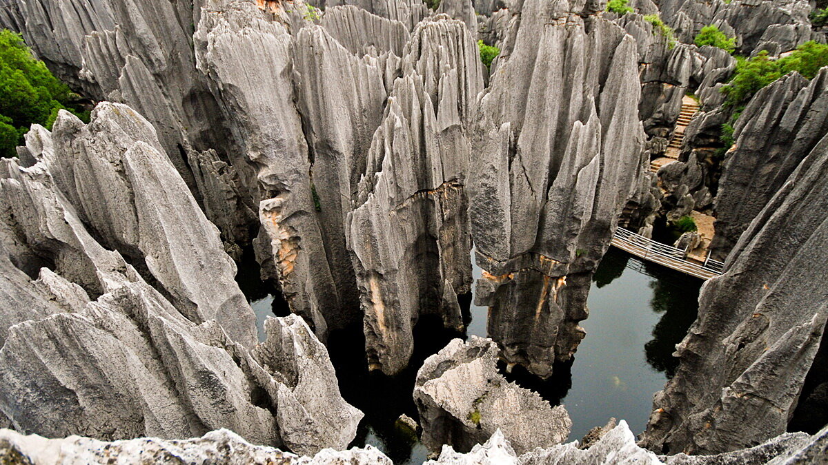 Каменный лес делится районы: большой и маленький лес, пещеры Жиюнь и Квифенг, каменный лес Найгу, лунное озеро и длинное озеро, водопад Да Диешиу. Еще он имеет подземную и надземную части.