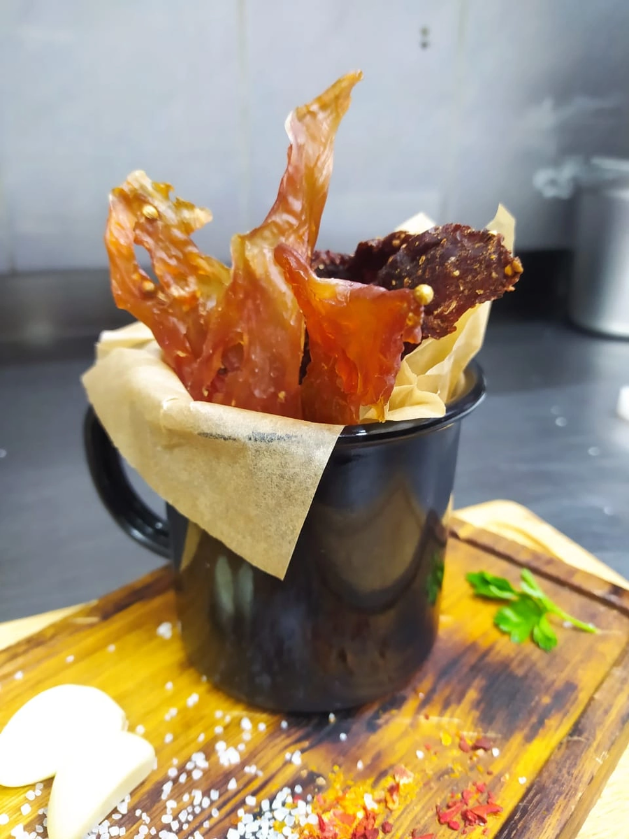 Сегодня  я Вам расскажу про прикольную закуску под названием Джерки- мясные чипсы или вяленое мясо — вот прямо дома, своими руками. И ничего сложного, совсем ничего!!! Ваши гости будут приятно удивлены, после того, как угостив их джерками Вы расскажите, что делаете их сами. В меню пивного ресторана фирменные джерки найдут себя в хоре пивных закусок и сетов. Их пряные голоса не оставят равнодушных. На бис!!! На бииис закричат люди)))) 

Состав специй для маринада, количество соли и ароматных трав легко довести до своего вкуса. Больше-меньше красного перца, да без проблем! У меня осталось 20 минут. Поэтому переходим к сути))) 

Джерки делают из филе птицы, говядины и свинины. Маринад должен быть пряным и концентрированным. Отработав чипсы в первый раз, я обнаружил, что соли не хватает. Поэтому первоначально допускаю легкий пересол. Варианты маринада классические. 

Маринад для грудки курицы или индейки на 300 грамм филе 

Соевый соус 40-50 грамм 
Чеснок сухой 5 грамм 
Соль крупная 5 грамм 
Мёд 10 грамм 
Имбирь сухой 3 грамма 
Глютамат натрия 3 грамма 
Капелька растительного масла 
Можно добавить немного нитритной соли 
*Количество и набор специй классический 
 
Маринад для говядины. Опять же на 300 грамм я возьму 

Кориандр зерно 5 грамм 
Специя для гриля 10 грамм 
Соль кошерная 5 грамм 
Можжевельник 1 грамм 
Немного тростникового сахара 
Глютамат 
Красный винный уксус 40-50 грамм 
Капелька масла 
 
Аккуратно перемешаем мясо и маринад. Оставим в прохладном месте на 10-12 часов под пленкой или в вакуумном пакете. Выложим на бумагу в дегидратор. В домашних полевых условиях вместо него используем печку. Можно немного открыть дверку, для конвекции. Температура 50 градусов. Среднее время изготовления 7-8 часов.
Из 300 грамм сырого продукта получается 100 грамм Джерки. Плюс 10-15 грамм на бракераж))) 

А теперь есть время сходить за пивасиком)))) 

Приятного аппетита!!! 