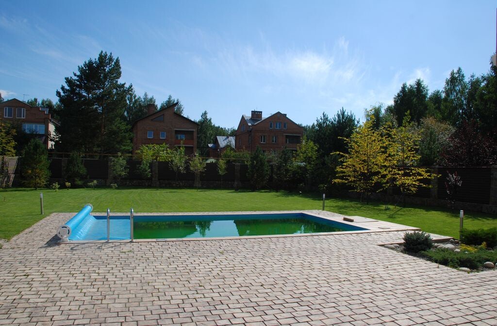 В центре бассейн, а вокруг рулонный газон.