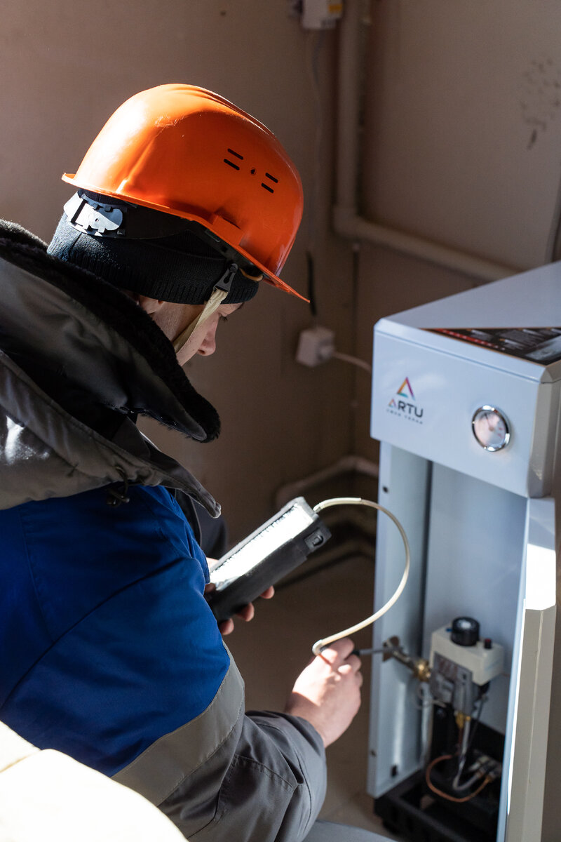 Специалист газовой службы проверяет работу котла