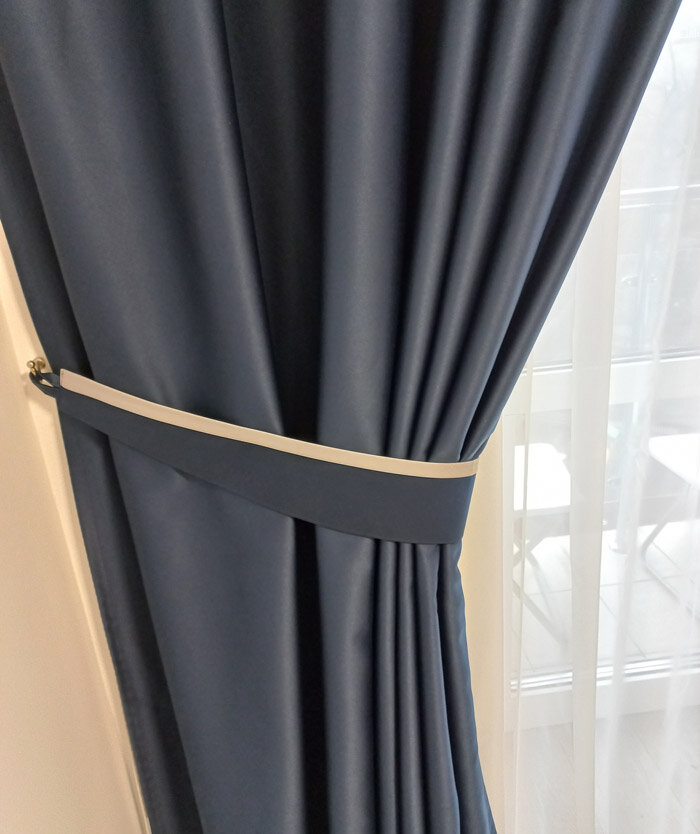 Шторы цвета Navy, синие на подхвате с бежевым кантом.