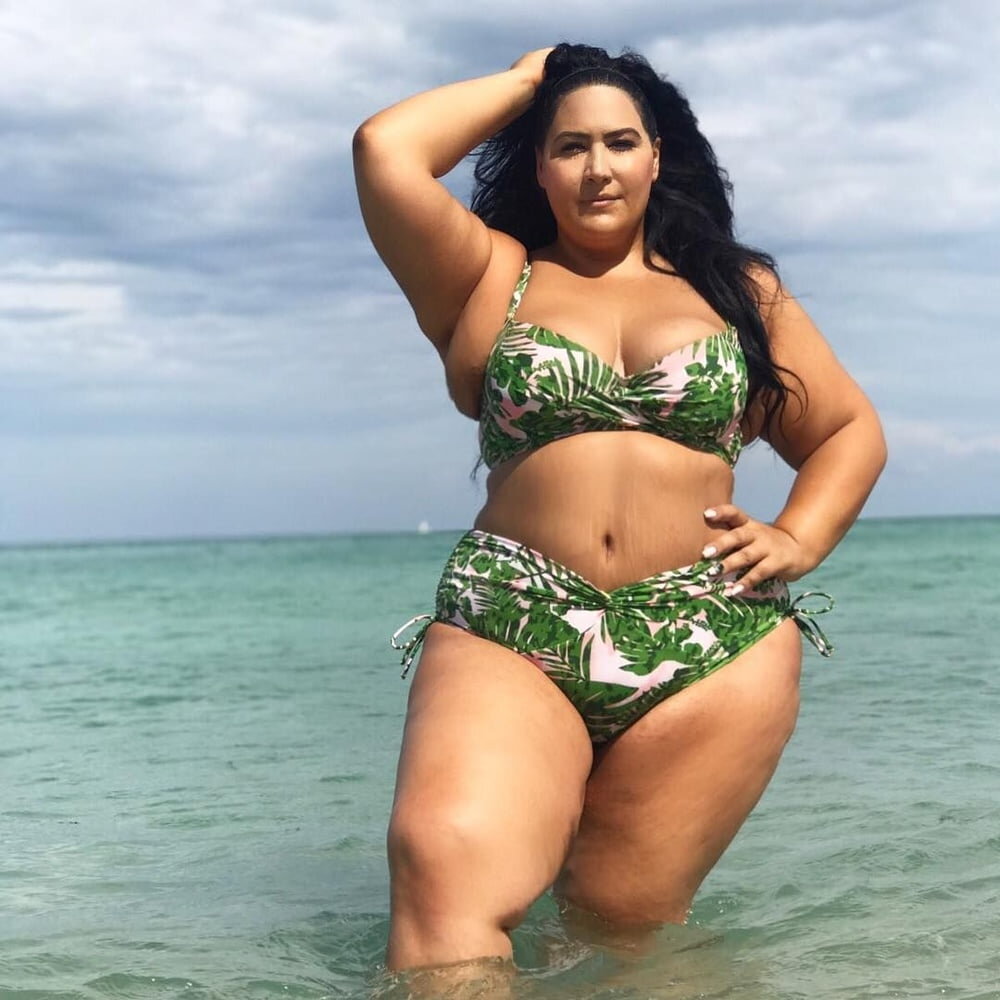 Толстая женщина сидит на пляже