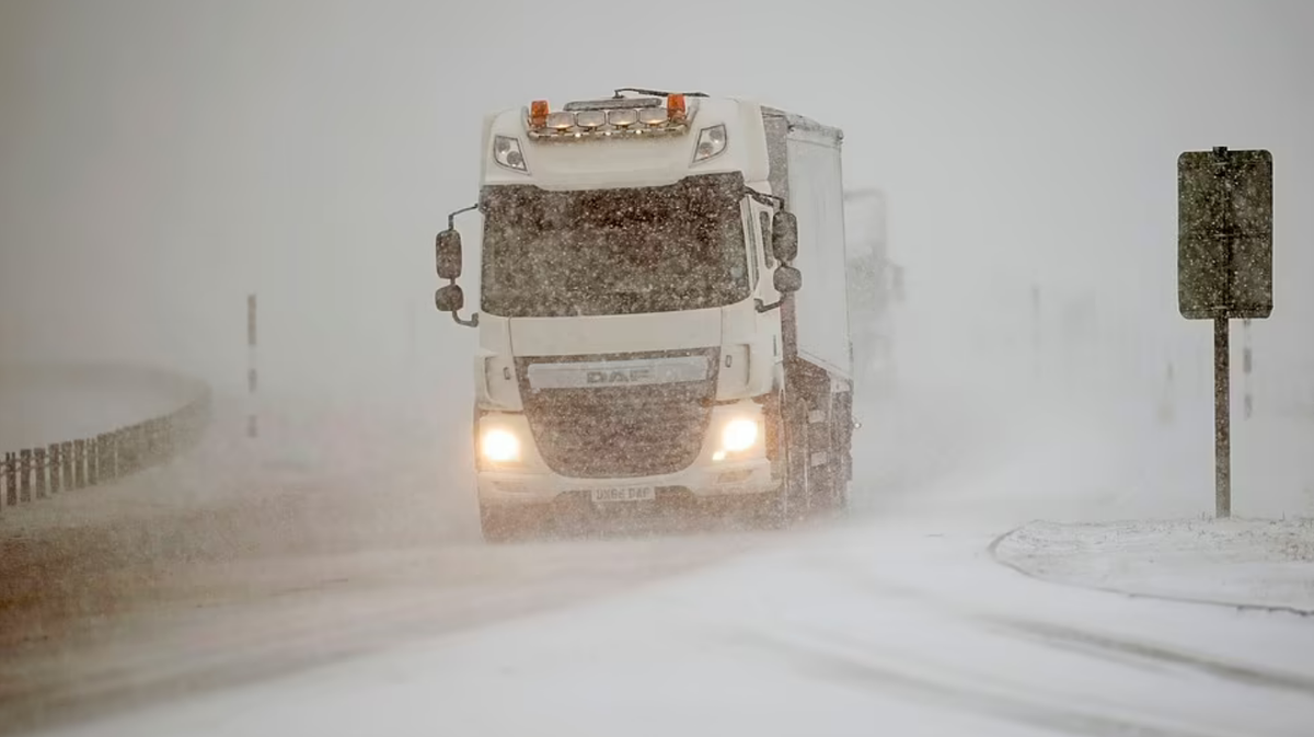Грузовик пробирается через падающий снег на автомагистрали A66 между Стейнмором и Боузом в графстве Дарем.