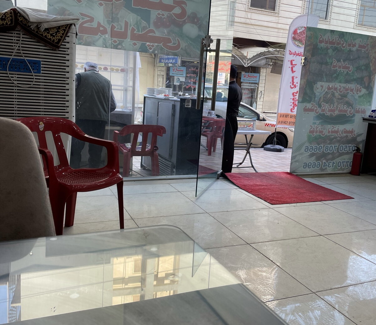 Фаст-фудная изнутри. Человек за стеклом готовит шашлык.