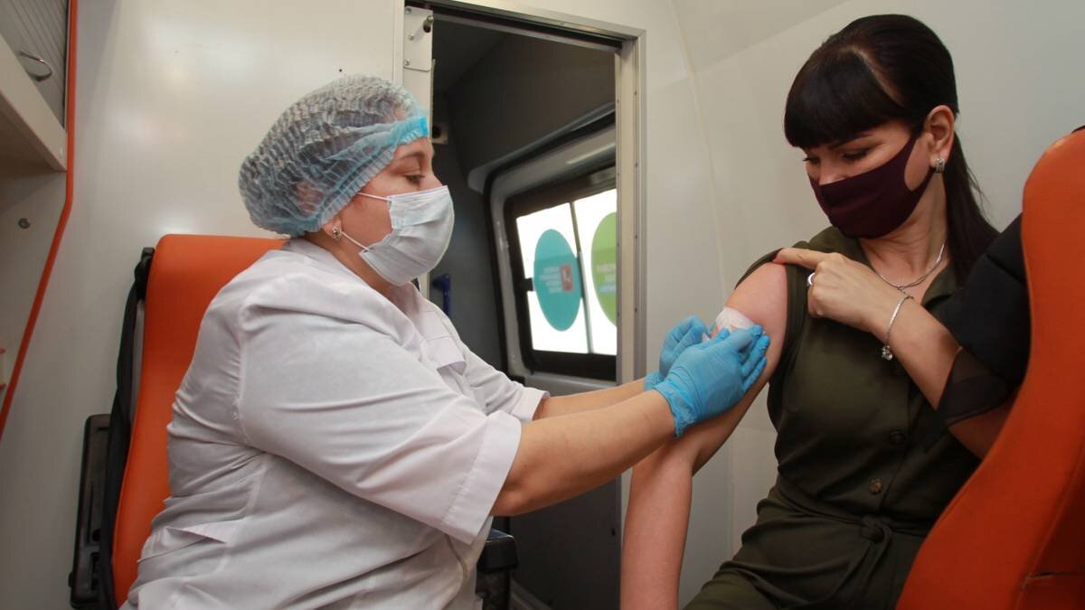    Медсестра Инга Жиздан делает прививку от гриппа пациентке Евгении Герасименко в одном из мобильных пунктов / Фото: Наталия Нечаева / Вечерняя Москва