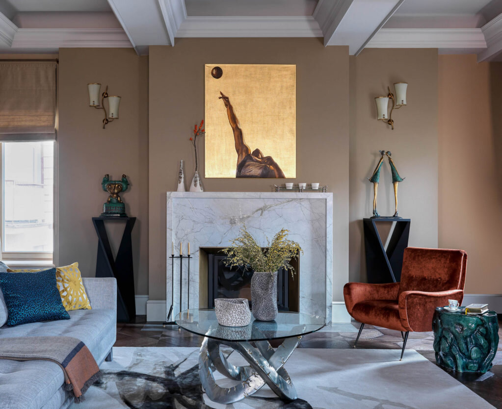  Гостиная на первом этаже. Камин изготовлен компанией Stone-Style, постаменты для бронзовых скульптур из коллекции заказчиков сделаны в столярной мастерской Владимира Митрохина. Бра над скульптурами винтажные, приобретены в компании “Свет и не только 50–60–70-х годов”; диваны, Roche Bobois; винтажные кресла из галереи Viva Vintage перетянуты бархатом Dedar; над камином работа Анастасии Марковской; на окнах текстиль, Baumann.