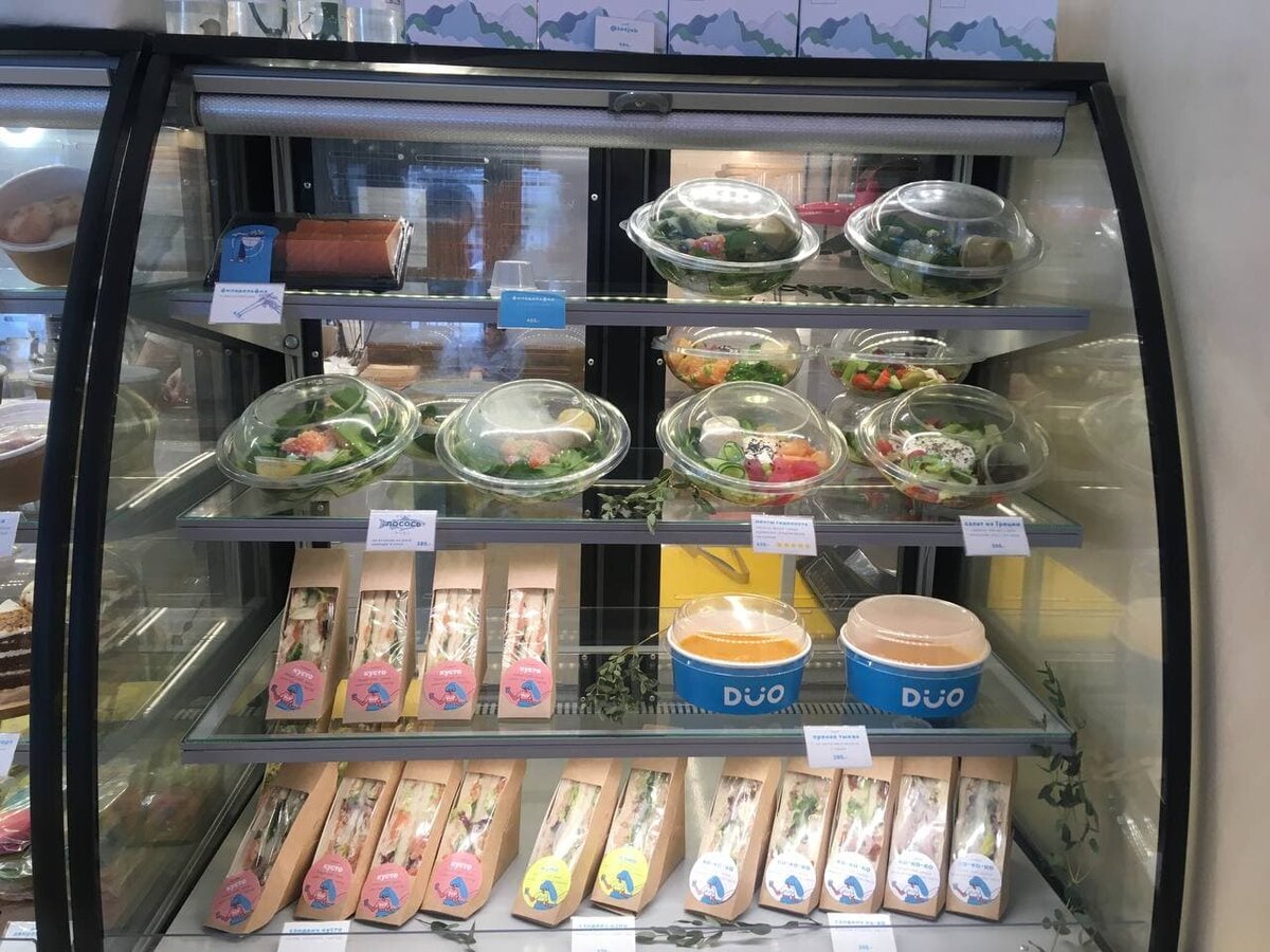 Витрина с основными блюдами, приготовленными заранее, витрина с десертами, а ещё что-то про завтраки – над витриной.