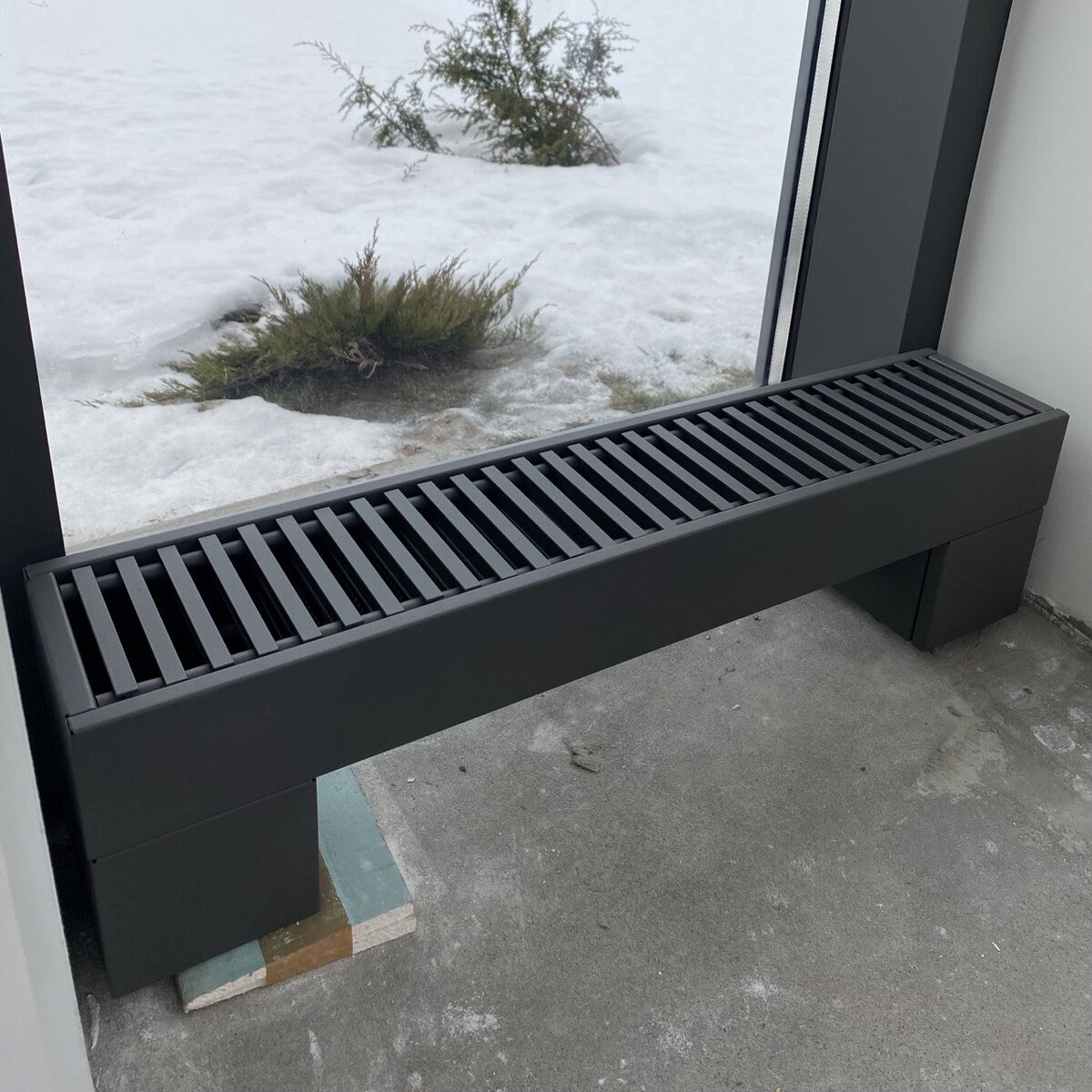 Радиатор отопления, покрашенный прямо на объекте в один цвет с окнами