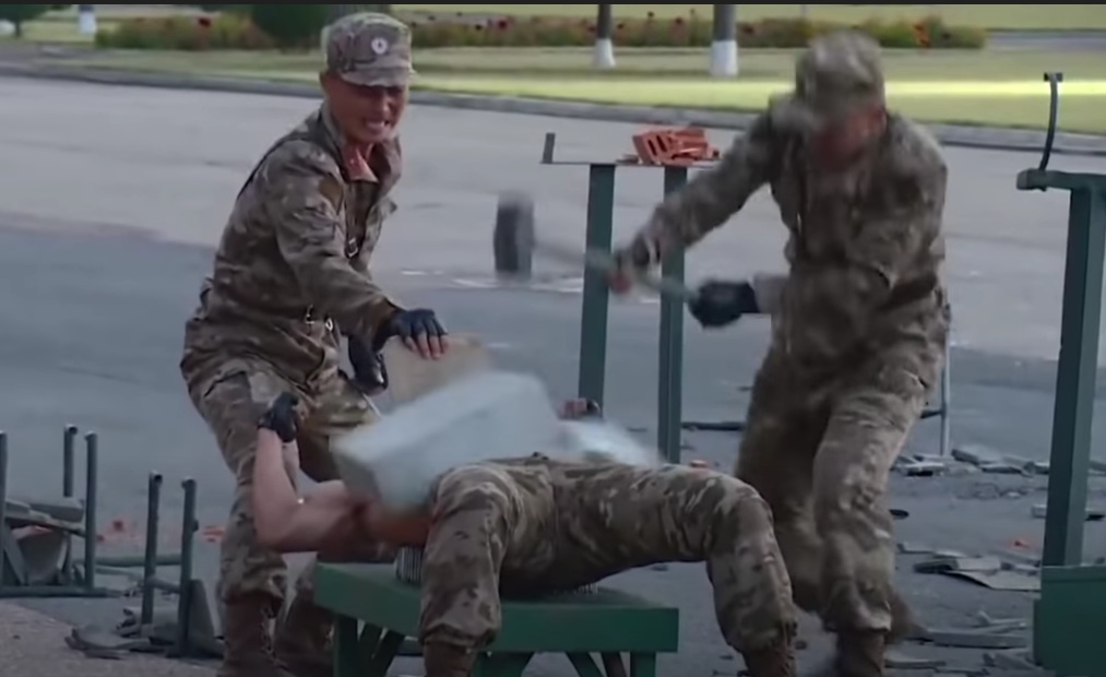 Корейский солдат лежит на гвоздях, и на нем разбивают плиту.