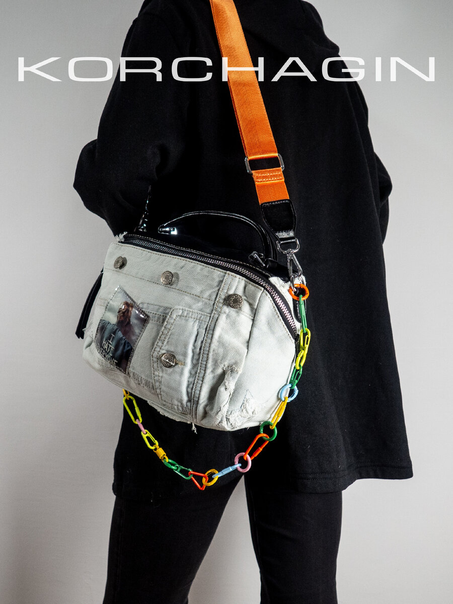 Сумка из денима и эко кожи черного цвета формы бочонка с ярким наплечным ремнём и цепочкой