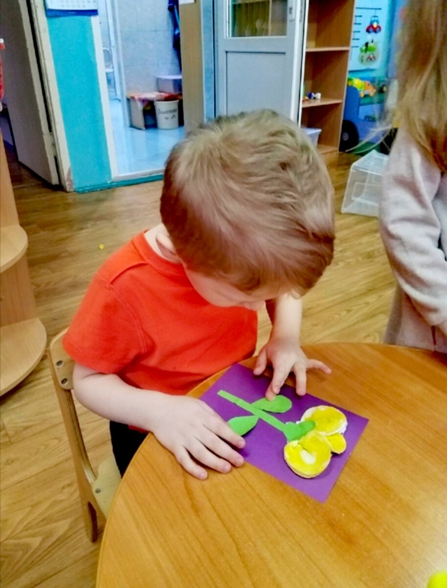 Трудится над аппликацией.