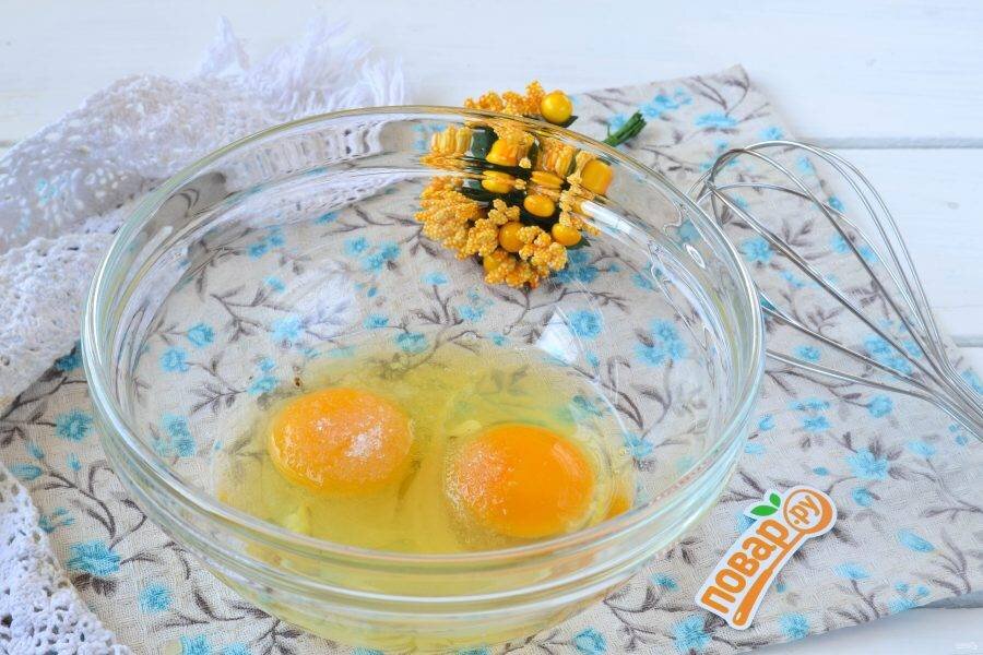 2. В глубокую миску разбейте яйца, добавьте щепотку соли и сахар по вкусу. Слегка взбейте ручным венчиком, чтобы яйца стали более-менее однородными.