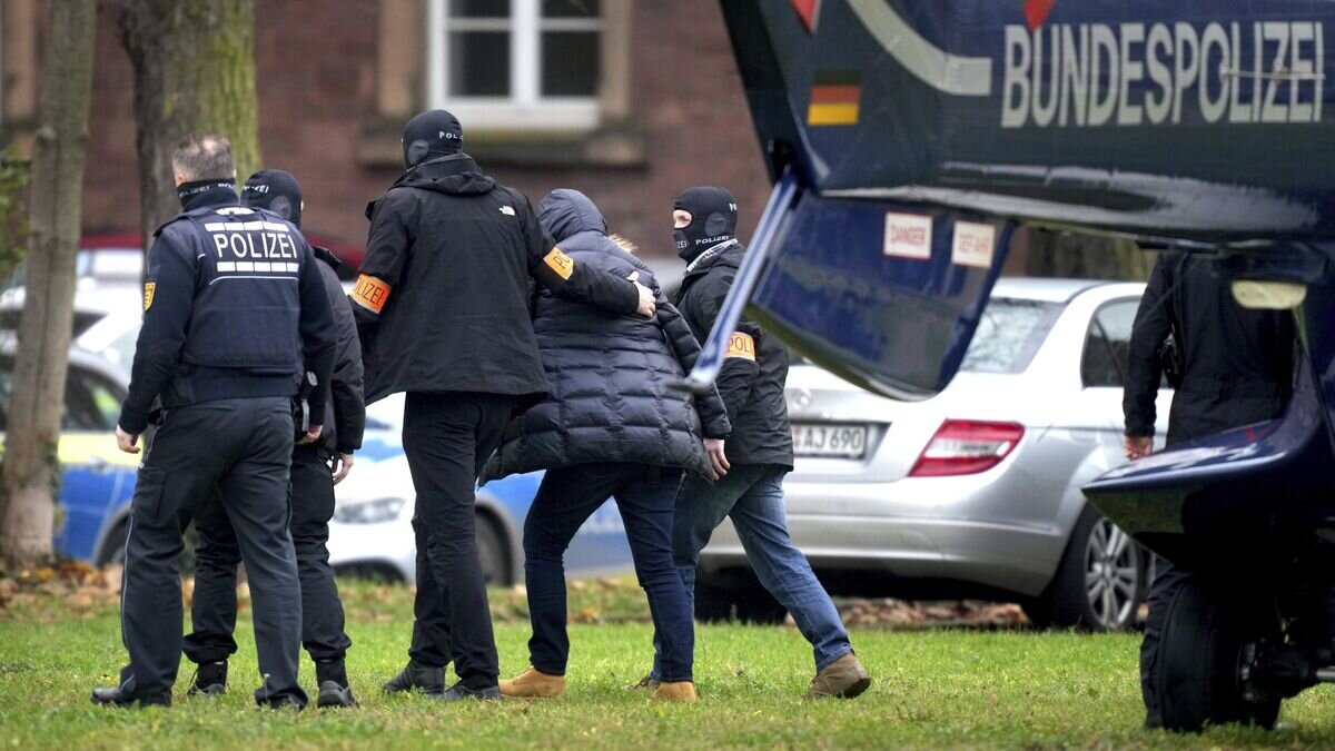    Сотрудники немецкой полиции сопровождают подозреваемого в Карлсруэ во время рейдов против членов крайне правой террористической группы, подозреваемых в планировании нападения на парламент Германии© AP Photo / Michael Probst