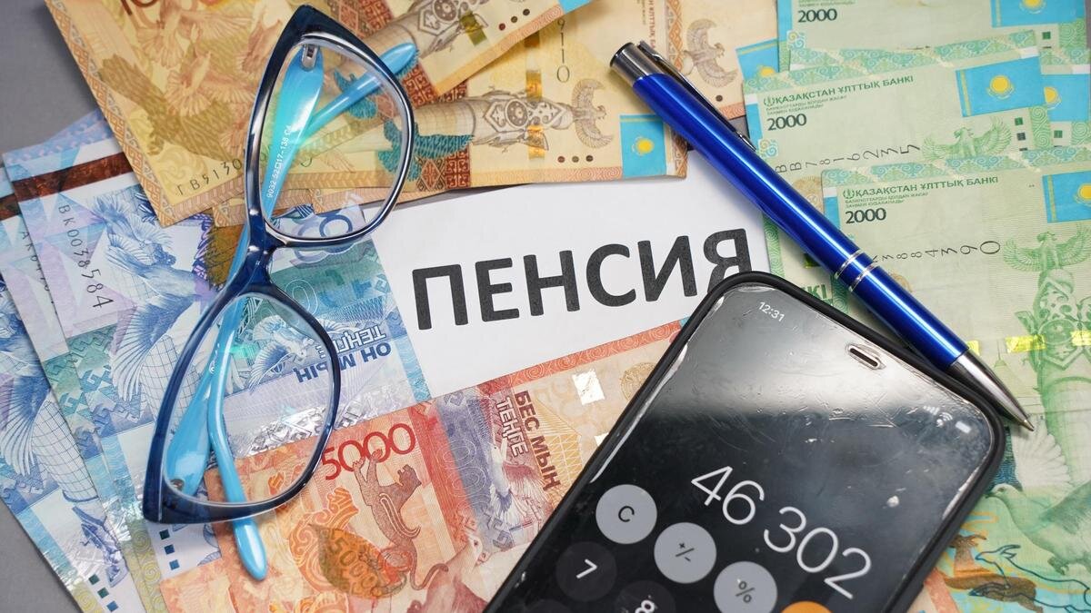    Смартфон ручка и очки лежат на купюрах тенге:NUR.KZ/Владимир Третьяков