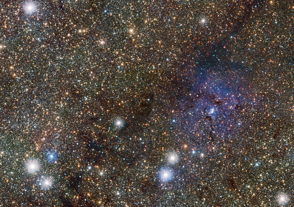    This small extract from the VISTA VVV survey of the central parts of the Milky Way shows the famous Trifid Nebula to the right of centre. It appears as faint and ghostly at these infrared wavelengths when compared to the familiar view at visible wavelengths. This transparency has brought its own benefits — many previously hidden background objects can now be seen clearly. Among these are two newly discovered Cepheid variable stars, the first ever spotted on the far side of the galaxy near its central plane. Анастасия Никифорова