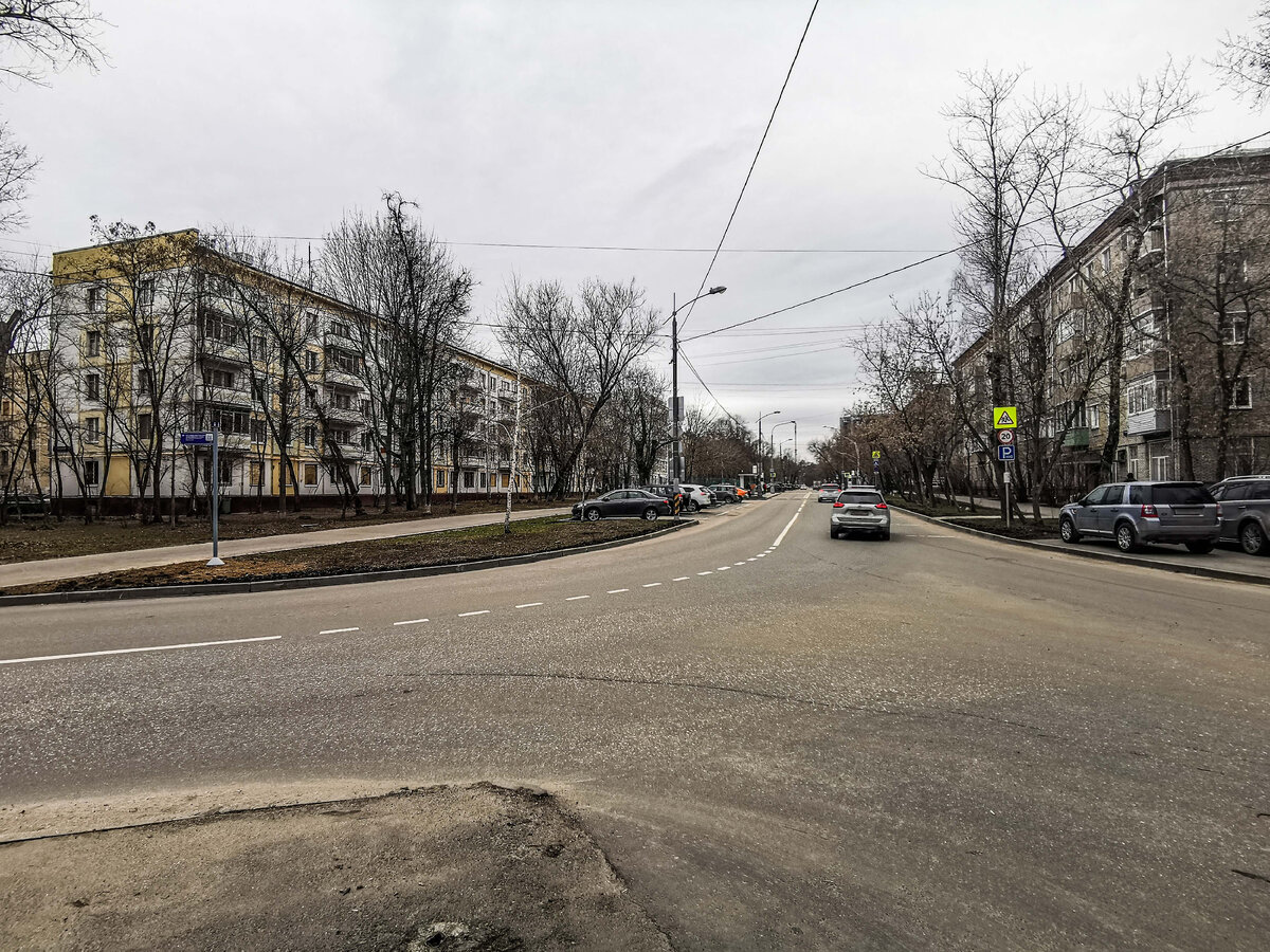 1-й Волоколамский проезд. Он проходит справа и туда прямо, а налево уходит улица Маршала Конева. Пятиэтажка слева приговорена к сносу, в момент съёмки её начали расселять, но в ней ещё теплится жизнь.