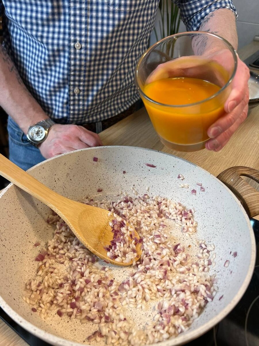 Дальше добавляем добавляем в рис половину морковного сока.